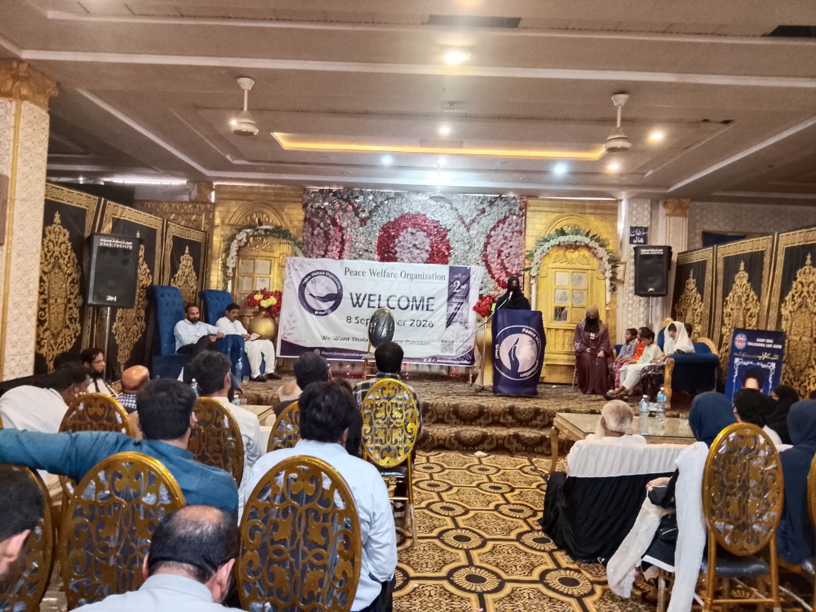A wide view of the conference hall as the proceedings continue on the decorated stage.